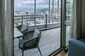 A balcony with a view of a cityscape, a table, and two chairs. - Bosmal Arjaan by Rotana (Sarajevo)