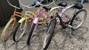 Three bicycles parked on a gravel surface.