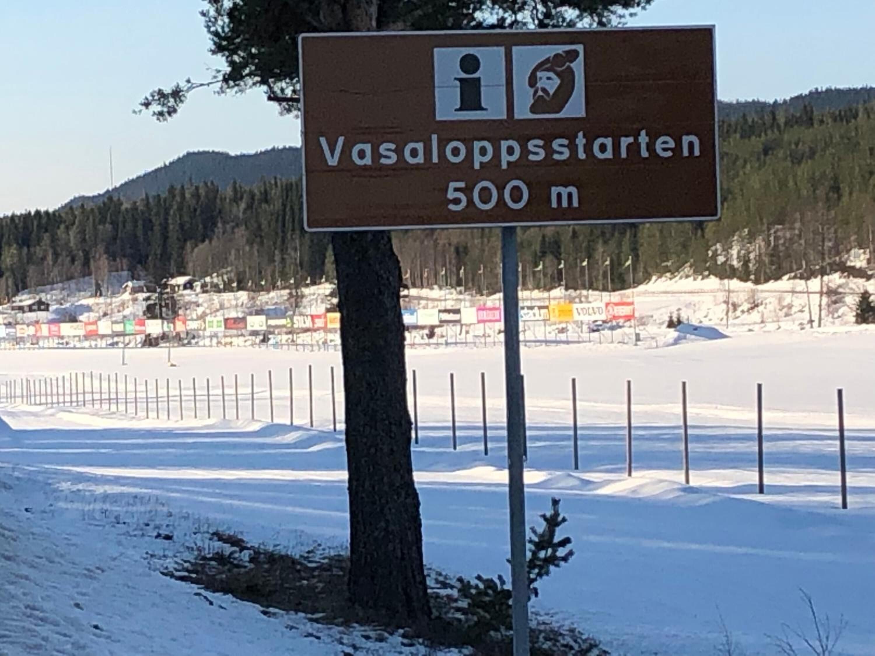 A sign indicating Vasaloppstarten 500m with a ski resort in the background.