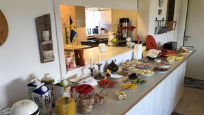 Eine Küchenarbeitsplatte mit verschiedenen Lebensmitteln und Küchenutensilien, darunter eine schwedische Flagge, eine Kaffeemaschine und eine Obstschale.
