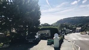 Una calle con un coche aparcado y un cartel de 'Plas Tion'.