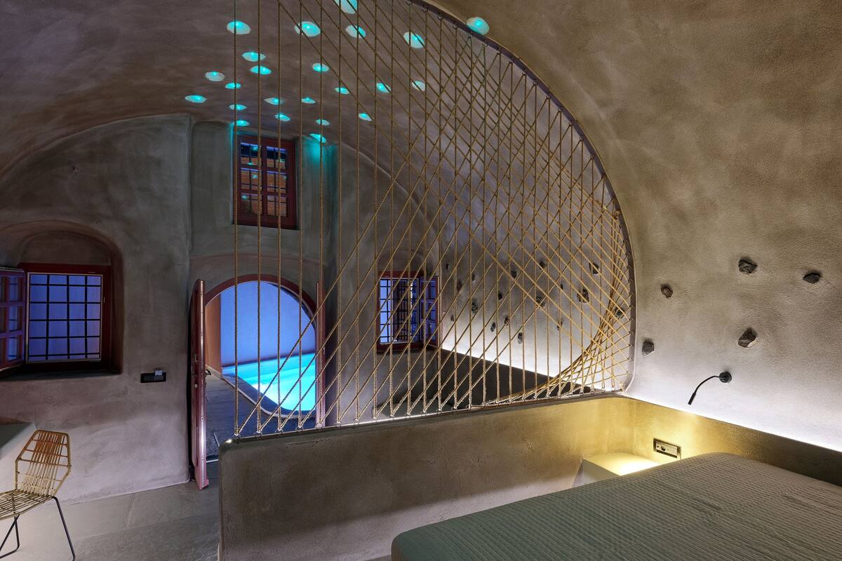 A room with a curved ceiling, a staircase, and a bed.