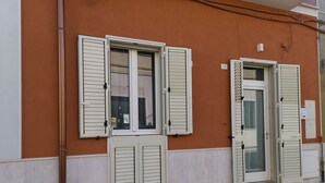 A building facade with three windows, each with shutters, and a visible number '78'. - Magnolia House (Montalbano)