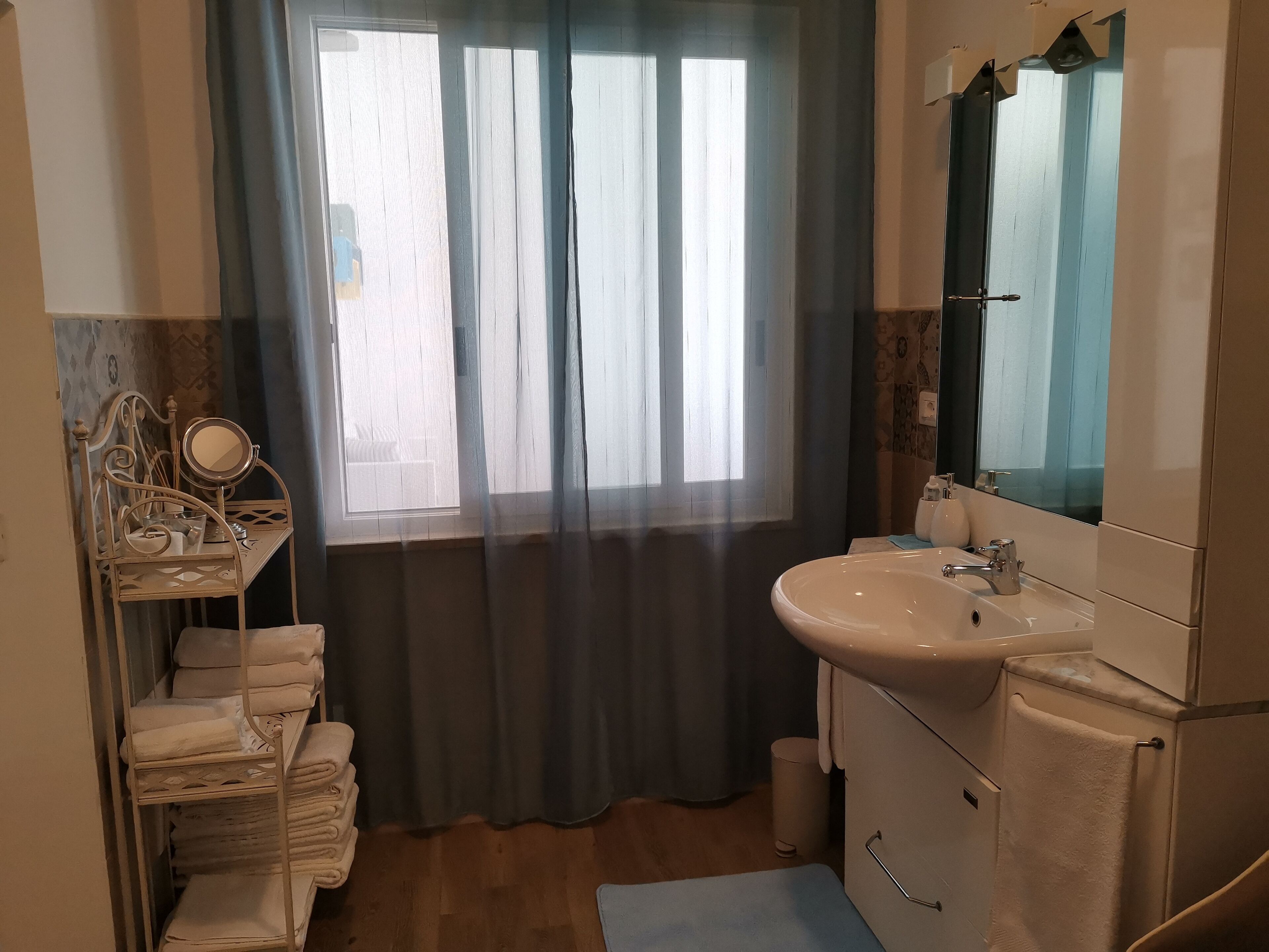 Une salle de bain avec un lavabo, un miroir et un porte-serviettes.