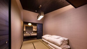 A hotel room with a traditional tatami mat floor, a bed with neatly folded white linens, and a modern ceiling light fixture. - Kanade Kawaramachinijo (Kyoto)