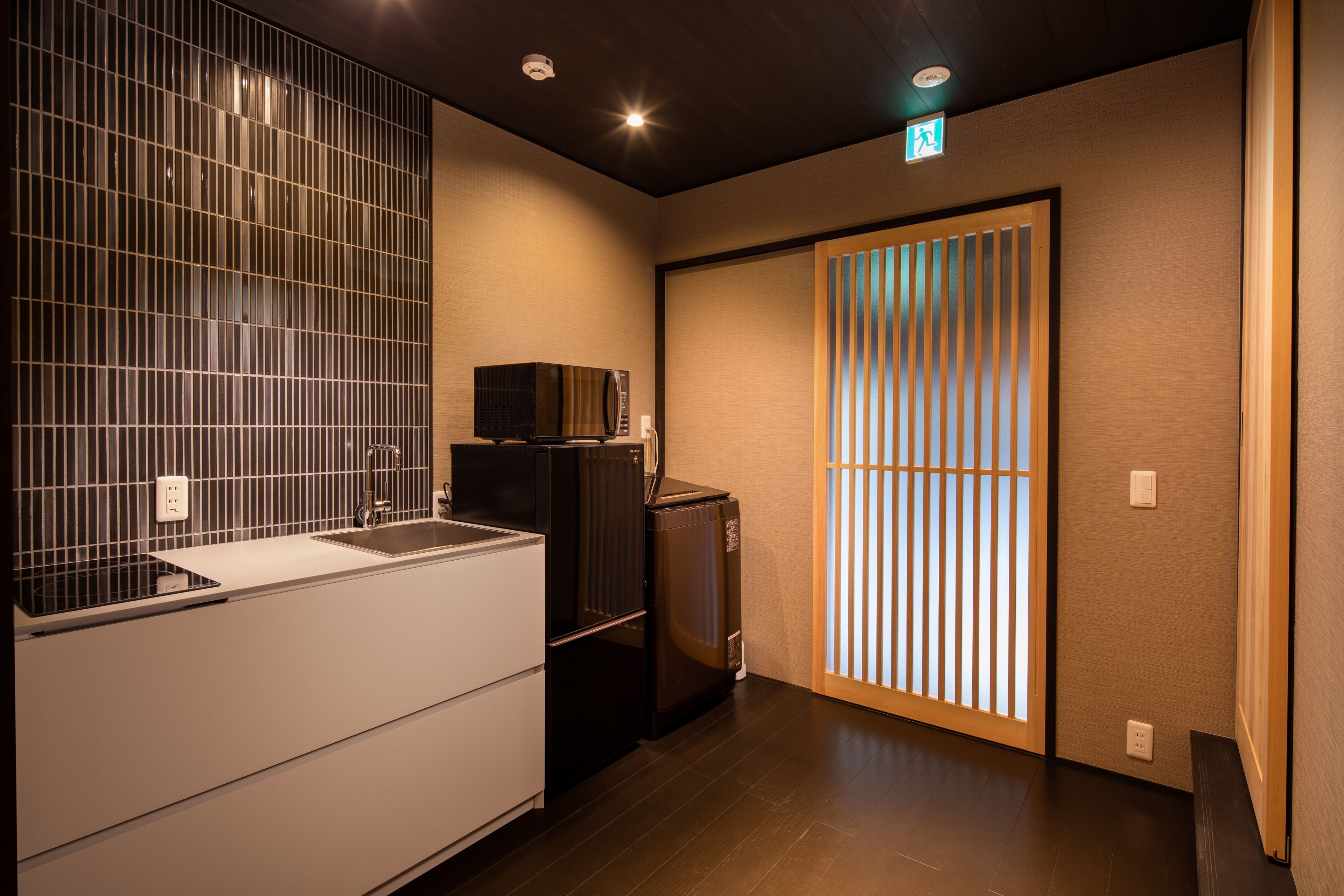 A modern kitchen with a sink, a microwave, and a refrigerator.