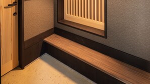A traditional Japanese-style room with sliding doors, a bench, and a textured wall. - Kanade Kawaramachinijo (Kyoto)