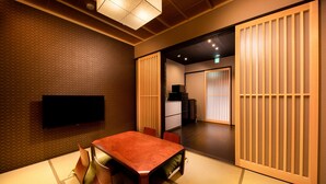 A traditional Japanese-style room with tatami flooring, a low table, and sliding doors. - Kanade Kawaramachinijo (Kyoto)