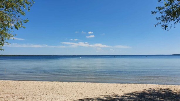 A beach with clear water, a sandy shore, and a distant horizon. - off in the summer 08 (Jabel)
