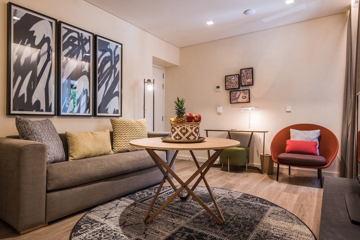 Ein modernes Wohnzimmer mit einer Couch, einem runden Couchtisch und einem Essbereich.