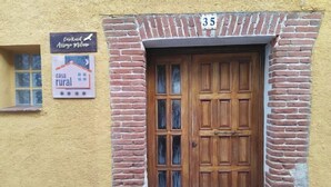 A rustic building with a wooden door and brick walls, labeled as 'casa rural'.