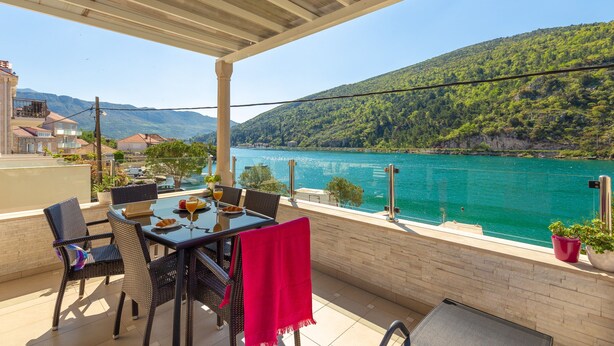 A terrace with a table and chairs overlooking a lake and mountains. - Hedera Estate, Hedera A24 (Dubrovnik)