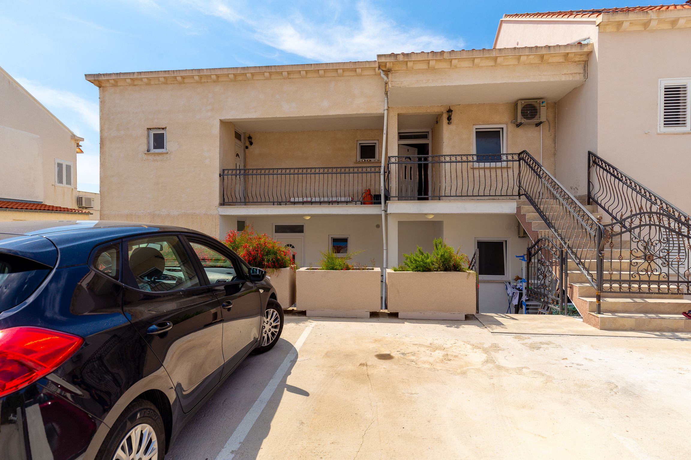A two-story building with a car parked in front.