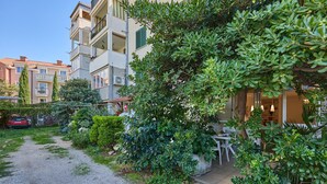 A residential area with a gravel path, green shrubs, and a building with balconies. - Hedera Estate, Hedera Studio 6 (Dubrovnik)