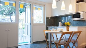 A modern kitchen with a dining area, large windows, and a view of the outdoors. - Hedera Estate, Hedera Studio 6 (Dubrovnik)