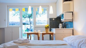 A hotel room with a bed, a desk, a chair, and a window with curtains. - Hedera Estate, Hedera Studio 6 (Dubrovnik)