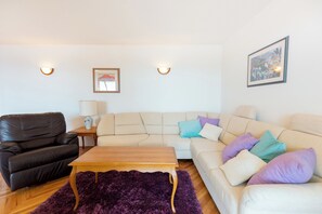 A living room with a sofa, a coffee table, a rug, and two wall-mounted lamps. - Hedera Estate, Hedera A13 (Dubrovnik)