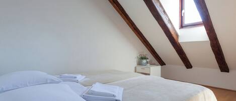 Une chambre à coucher avec un lit, des oreillers, une table de chevet et une fenêtre.