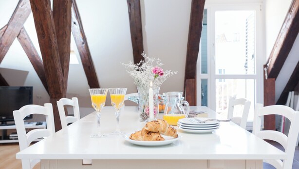 A dining table with breakfast items, a vase with flowers, and a window with a view. - Hedera Estate, Hedera A5 Apartment (Dubrovnik)