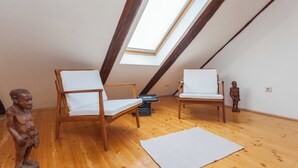 An attic room with wooden floors, two white cushioned chairs, a small rug, a sculpture, and a skylight. - Hedera Estate, Hedera A5 Apartment (Dubrovnik)