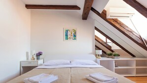 A bedroom with a bed, a nightstand, a lamp, a painting, and a wooden ceiling. - Hedera Estate, Hedera A5 Apartment (Dubrovnik)
