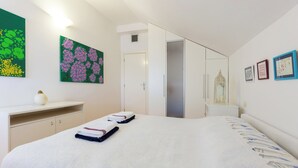 A bedroom with a bed, a desk, a wardrobe, and a door leading to another room. - Hedera Estate, Hedera A14 (Dubrovnik)