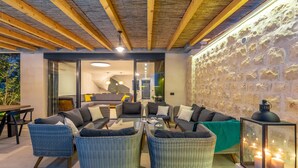 A cozy outdoor seating area with wicker furniture and a stone wall backdrop. - Hedera Estate, Villa Hedera II (Dubrovnik)
