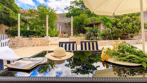 An outdoor patio with a table, chairs, and a large umbrella. - Hedera Estate, House Hedera V (Dubrovnik)