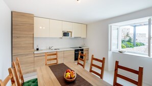 Une cuisine moderne avec des meubles en bois, un four à micro-ondes et un coin repas comprenant une table et des chaises.