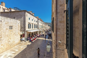 A narrow street lined with stone buildings, outdoor seating for cafes, and a clear blue sky. - Hedera Estate, Hedera A2 Apartment (Dubrovnik)
