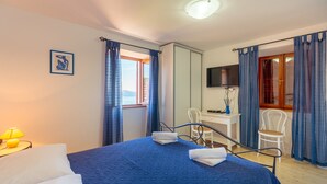 A hotel room with a bed, a desk, a chair, and a television. - Hedera Estate, Villa Hedera XI (Dubrovnik)