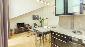 Eine moderne Küche mit Bar, einem Esstisch und einem Fernseher.