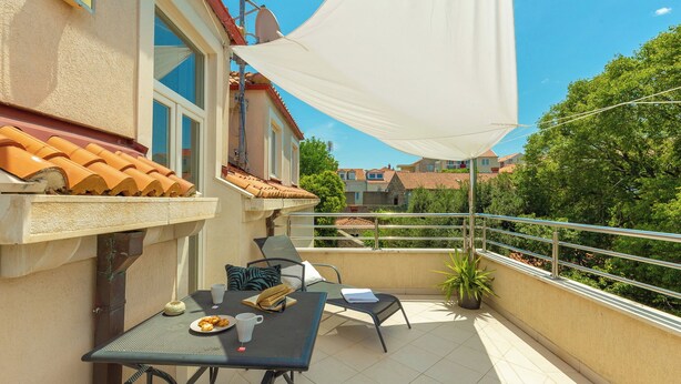 Ein Balkon mit Tisch, Stühlen und einer weißen Markise.