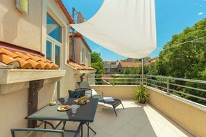 A balcony with a table, chairs, and a white canopy. - Hedera Estate, Hedera A1 (Dubrovnik)