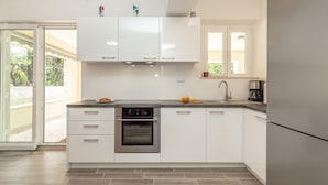 A modern kitchen with white cabinets, a built-in oven, and a stainless steel refrigerator. - Hedera Estate, Villa Hedera V (Dubrovnik)