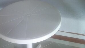 Une pièce avec un canapé blanc et une table ronde. Il y a trois tableaux accrochés au mur.