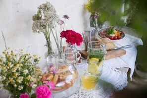 Une table dressée avec de la nourriture, des boissons et des fleurs.