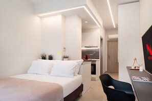 A modern hotel room with a bed, a desk, and a TV. - Thess Residences (Thessaloniki)