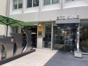 Ein modernes Gebäude mit einer Schaufensterfassade mit der Aufschrift "270 KING" und einem Außenbereich mit grüner Markise.