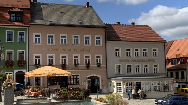 A historic building with the name "HOTEL GOLDNER LÖWE" on the facade, featuring a traditional European architectural style with a tiled roof and multiple windows. - Goldner Löwe (Stolpen)