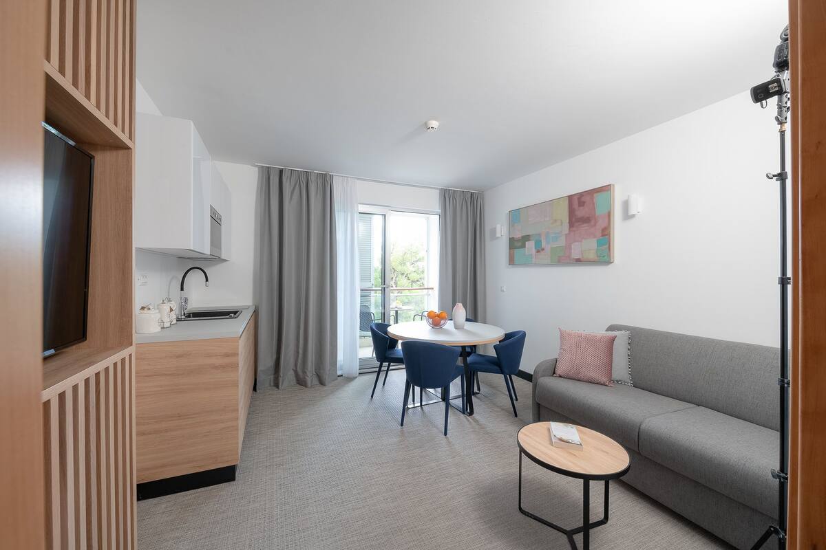 Ein modernes Zimmer mit Küche, Essbereich und einer Couch.