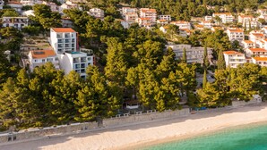 Vue aérienne d’une ville côtière, avec ses bâtiments, sa plage et une végétation luxuriante.