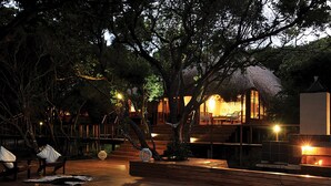 A wooden deck with a swimming pool, outdoor seating, and a fire pit area. - Cabo Beach Villas (Machangulo)