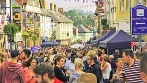 A crowded street with market stalls and tents, indicating a busy public event or market. - Hardwick Farm (Abergavenny)