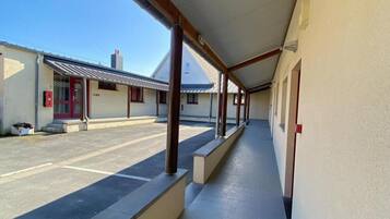 A covered walkway with a tiled floor leading to a building entrance.