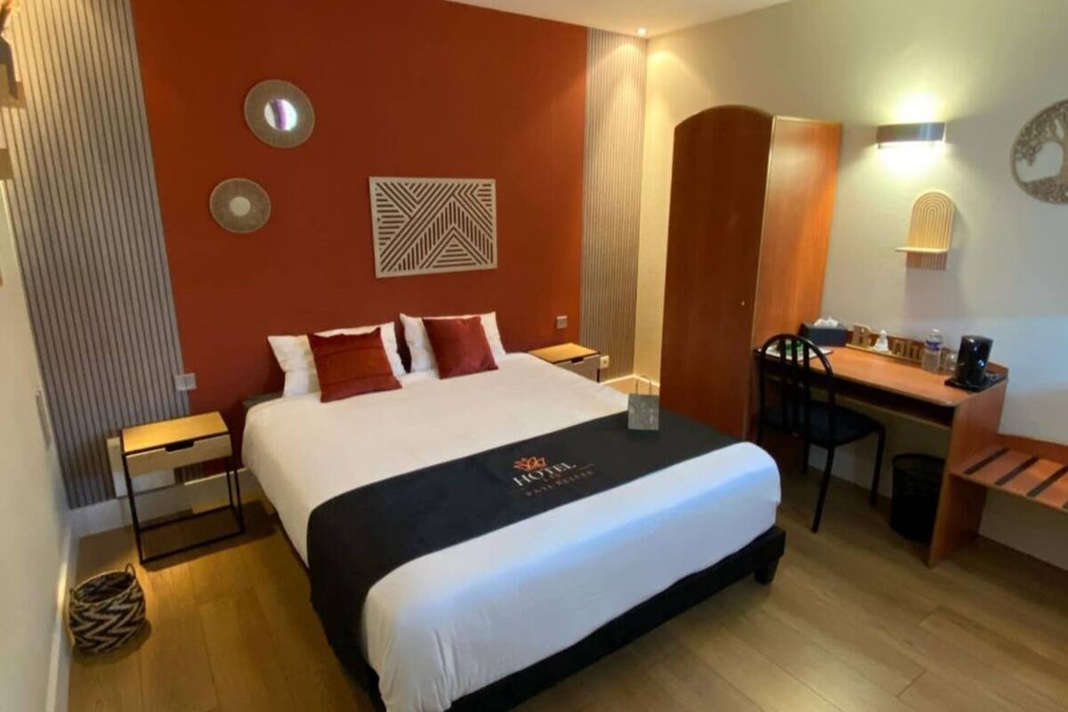 Ein Hotelzimmer mit einem großen Bett, einem Schreibtisch und einem Stuhl.