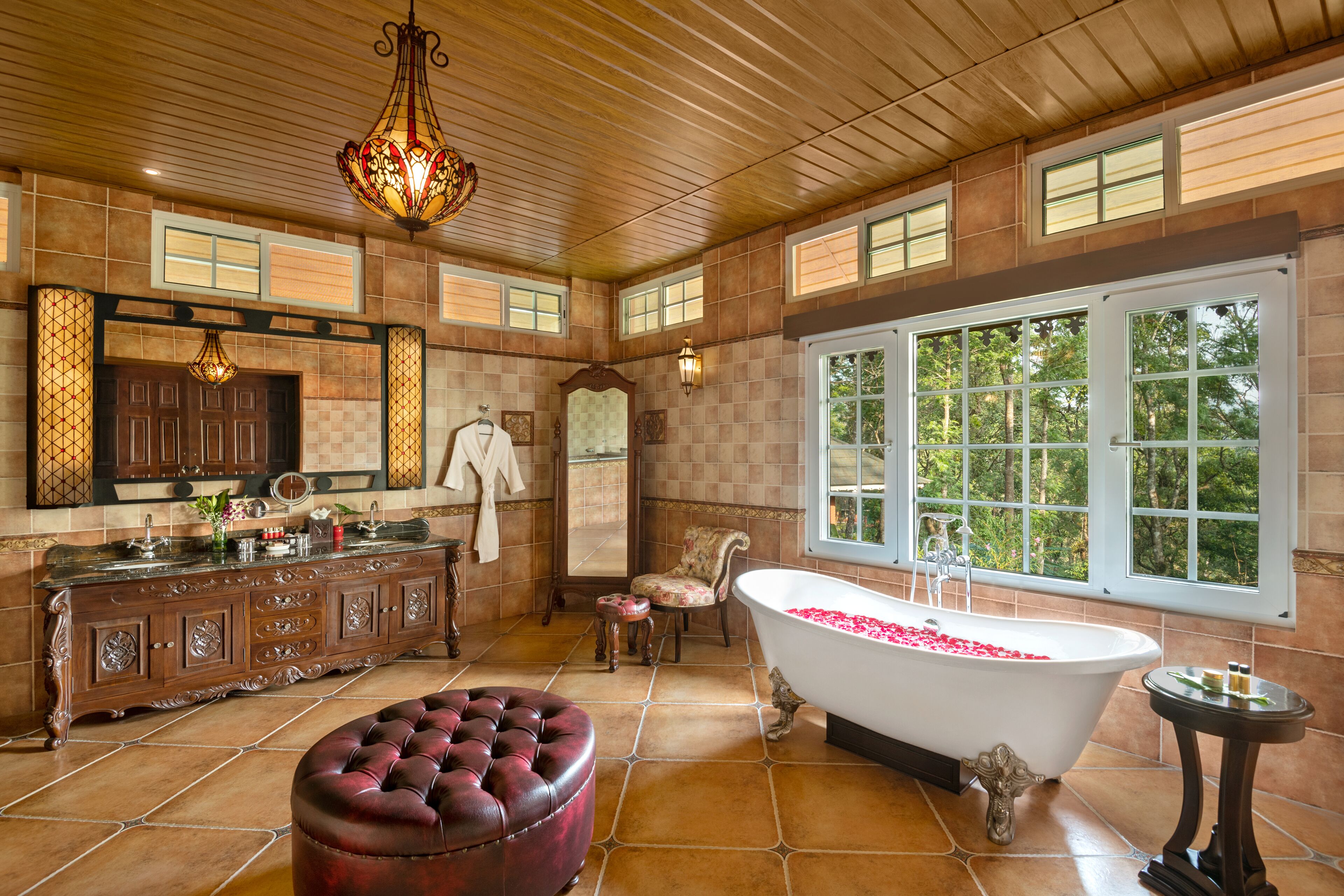 A spacious bathroom with a large bathtub, a vanity with a mirror, and a wooden ceiling.