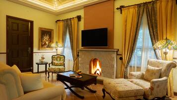 Una sala de estar acogedora con chimenea, asientos cómodos y televisor.