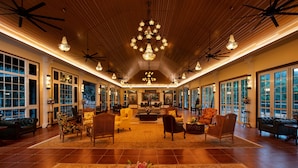 A spacious lobby with a high ceiling, chandeliers, and large windows.
