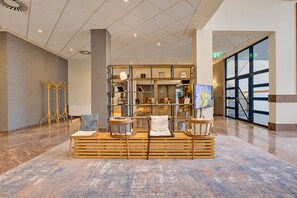 A lobby area with a seating arrangement, a reception desk, and a large window providing a view.